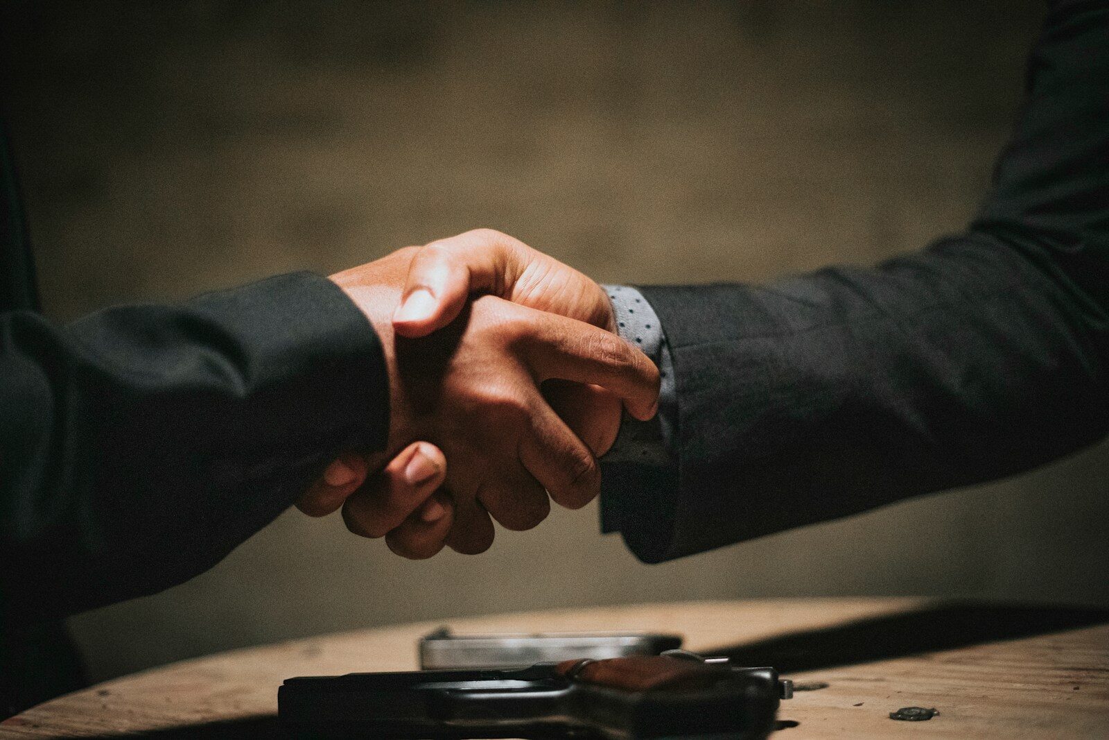 Photo by Rock Staar two people shaking hands over a wooden table